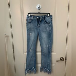 Distressed ankle length fringed jeans